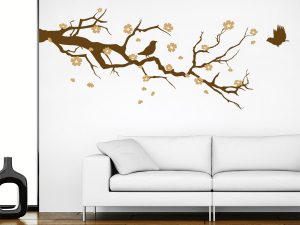 طرح استیکر دیواری زیبا و پر فروش روی دیوار برچسب دیواری شاخه شکوفه گیلاس که روی دیوار سفید گچی از کنار دیوار همراه با پرنده های و شکوفه های صورتی نصب شده است