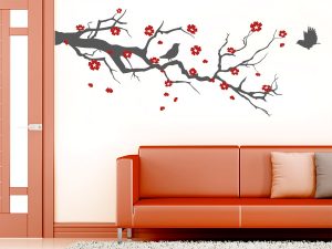 طرح استیکر دیواری زیبا و پر فروش روی دیوار برچسب دیواری شاخه شکوفه گیلاس که روی دیوار سفید گچی از کنار دیوار همراه با پرنده های و شکوفه های صورتی نصب شده است
