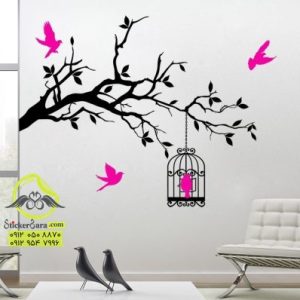 طرح برچسب دیواری یا استیکر روی دیوار که از گوشه دیوارشاخه بزرگ با قفس و پرندهای در حال پرواز نصب شده است