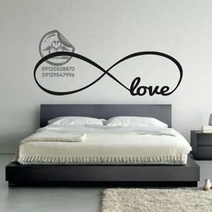 استیکر دیواری اتاق خواب طرح love نصب شده روی تخت رنگ مشکی سایز بزرگ