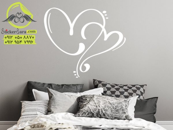 طرح استیکر برچسب دیواری نماد عشق دوستی دو قلب عاشق که بر روی سر یا تاج تخته خواب نصب شده است